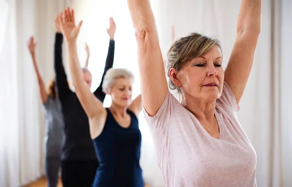 Grupp av seniora människor som gör yoga övning i Community Center Club. — Stockfoto