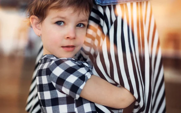 Een close-up van een klein meisje dat door het raam kijkt. — Stockfoto