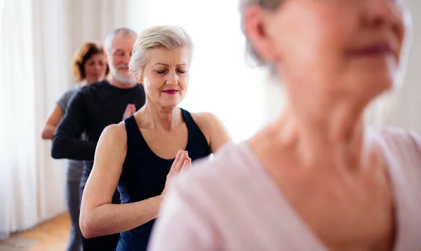 Grupp av seniora människor som gör yoga övning i Community Center Club. — Stockfoto