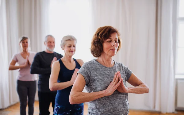 Grupo de personas mayores haciendo ejercicio de yoga en club de centro comunitario . —  Fotos de Stock