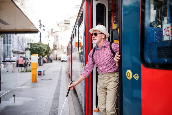 Cego sênior com bengala branca saindo do transporte público na cidade . — Fotografia de Stock