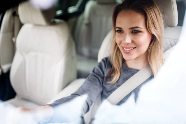 Ung kvinna förare sitter i bilen, körning. — Stockfoto