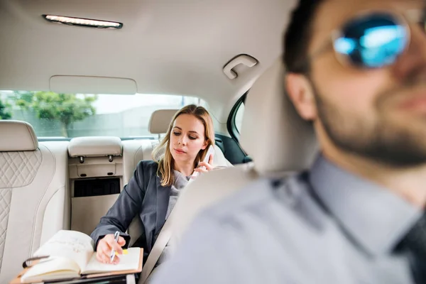 Mujer de negocios con teléfono inteligente sentado en el asiento trasero en el coche de taxi, hablando . — Foto de Stock
