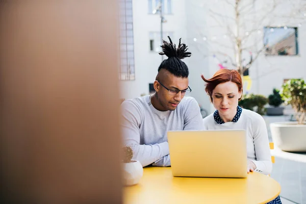 Jonge zakenlui met laptop in binnenplaats, start-up concept. — Stockfoto