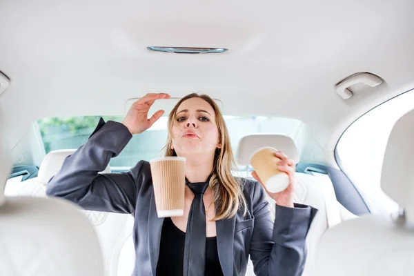 Ung frustrerad kvinna med tomma pappers glasögon sittande i bilen. — Stockfoto