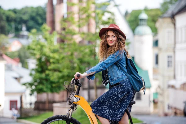 Küçük bir kasabada elektrikli scooter ile güzel genç kadın turist gezgin. — Stok fotoğraf