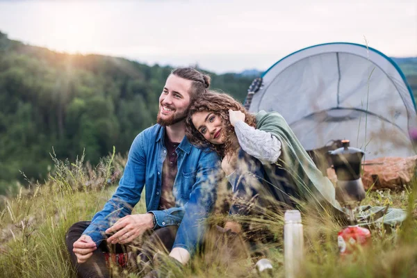 Молодые туристы пара путешественников с палаточным домиком сидят на природе, отдыхают . — стоковое фото