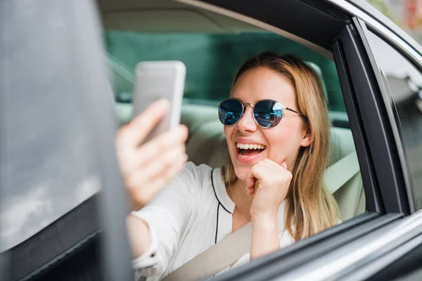 Business woman sitting on back seat in taxi car, taking selfie. — Stock Photo, Image