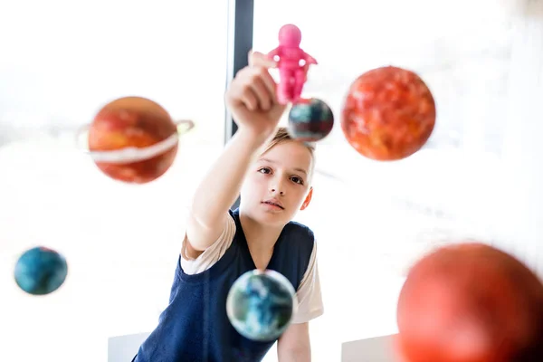 Un niño pequeño con modelo de sistema solar en el interior . — Foto de Stock