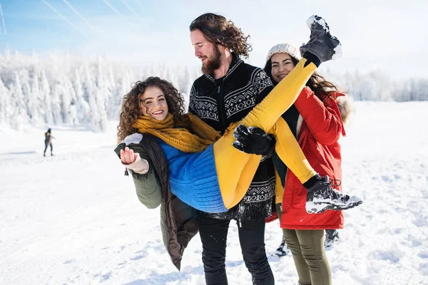 Un grupo de jóvenes amigos en un paseo al aire libre en la nieve en el bosque de invierno . —  Fotos de Stock