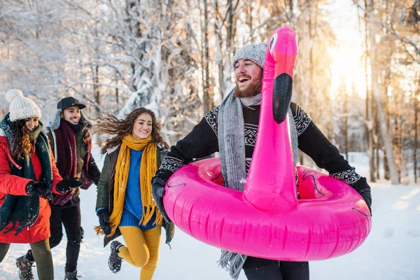 冬の森の雪の中を散歩する若い友人のグループ. — ストック写真