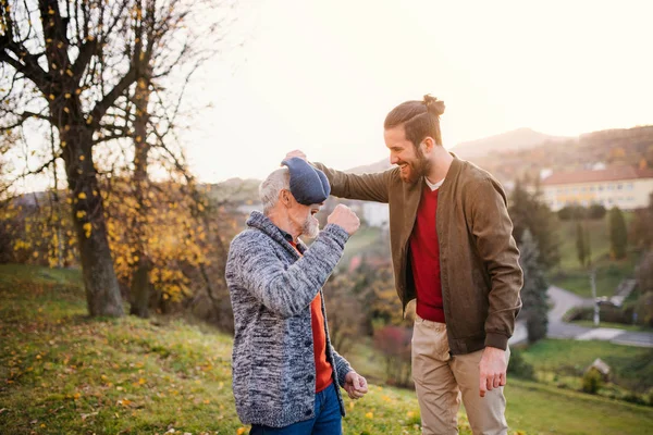 Young man and his senior father in nature, having fun. — Stock Photo, Image