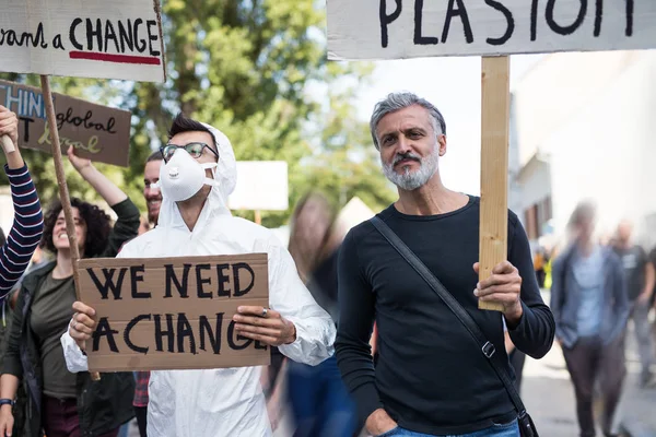Pessoas com cartazes e roupa protetora em greve global por mudanças climáticas . — Fotografia de Stock
