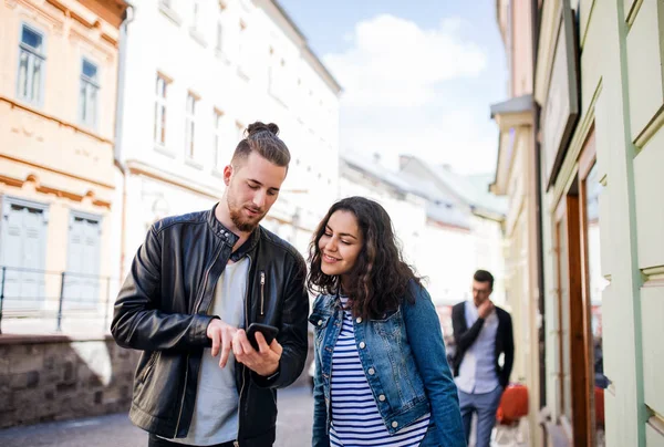 Unga vänner med smartphone stående utomhus i stan, talar. — Stockfoto