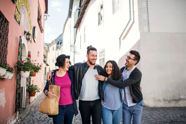 Un grupo de jóvenes amigos caminando al aire libre en la ciudad, hablando . — Foto de Stock