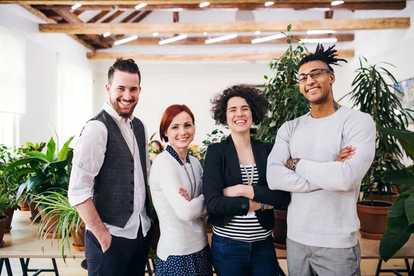 Groep jonge zakenlui die in functie staan, kijkend naar de camera. — Stockfoto