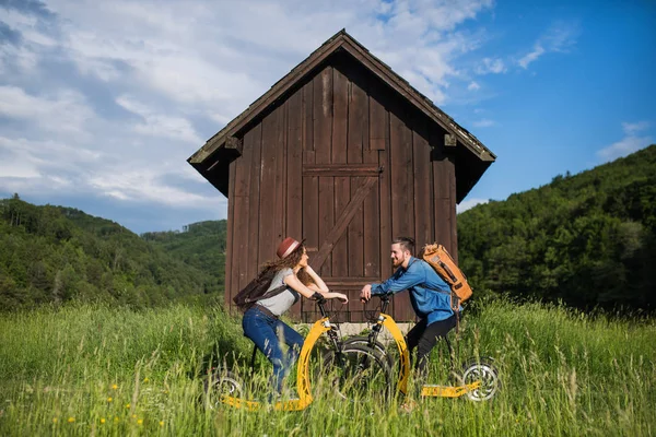 Junges Touristenpaar mit Elektroroller in der Natur, um sich auszuruhen. — Stockfoto