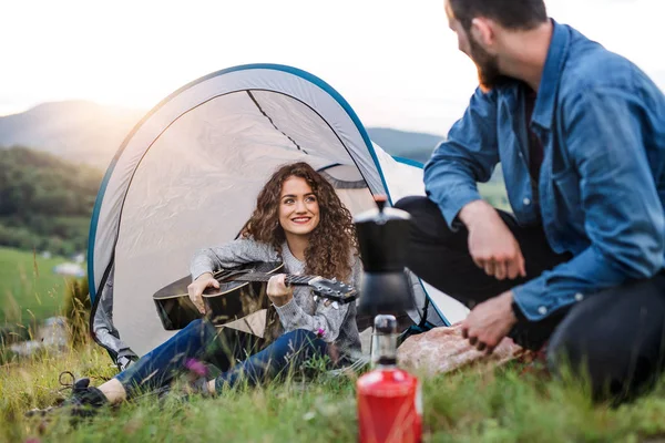 Young tourist couple travellers with tent shelter sitting in nature, resting. — Stock Photo, Image