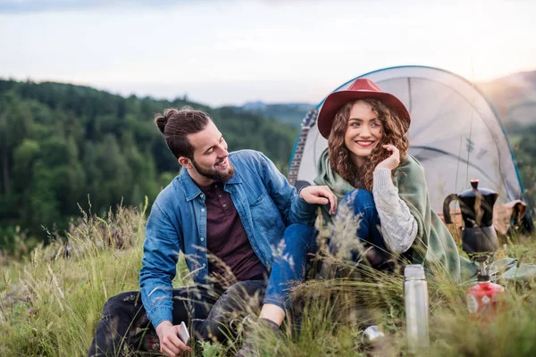 Genç turist çift doğada oturan çadır barınak ile gezginler, dinlenme. — Stok fotoğraf