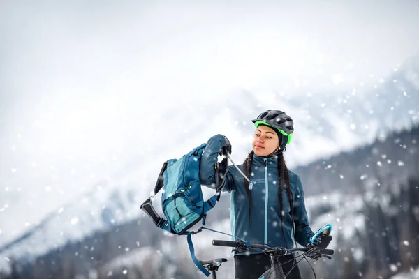 Mountainbikerin steht im Winter draußen auf der Straße. — Stockfoto