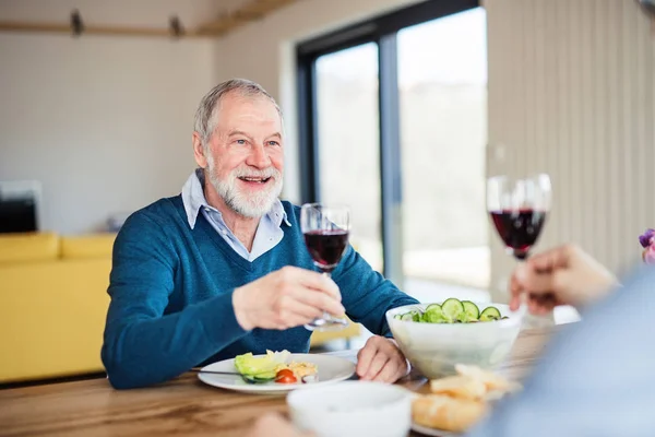 Ein erwachsener Hipster-Sohn und ein älterer Vater zu Hause und essen ein leichtes Mittagessen. — Stockfoto