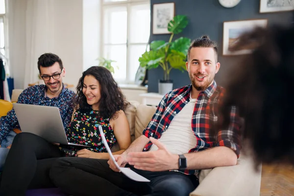 Un grupo de jóvenes amigos con portátil en el interior, concepto de compartir casa . — Foto de Stock