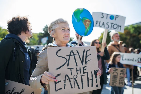 Senior met plakkaat en poster op wereldwijde staking voor klimaatverandering. — Stockfoto