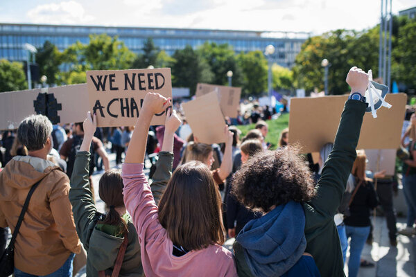 Rear view of people with placards and posters on global strike for climate change.