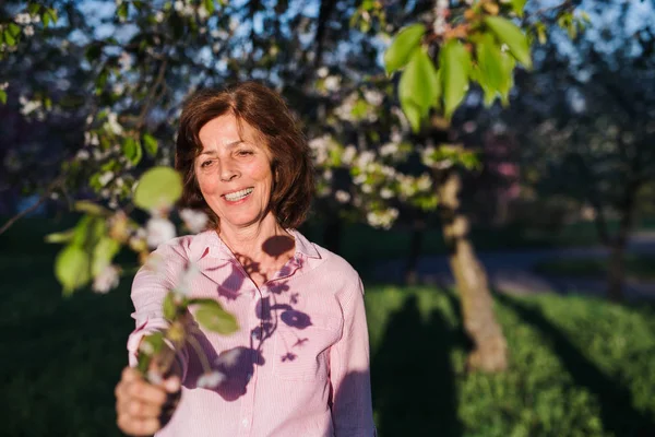 Schöne Seniorin, die draußen in der Frühlingsnatur steht. Kopierraum. — Stockfoto