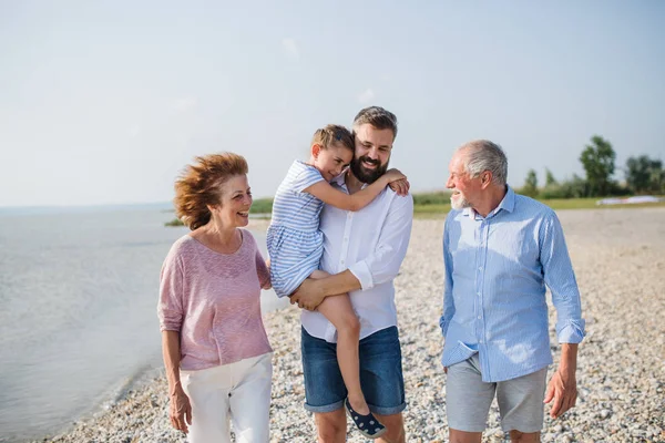 Familia multigeneracional en unas vacaciones caminando por el lago, hablando . — Foto de Stock