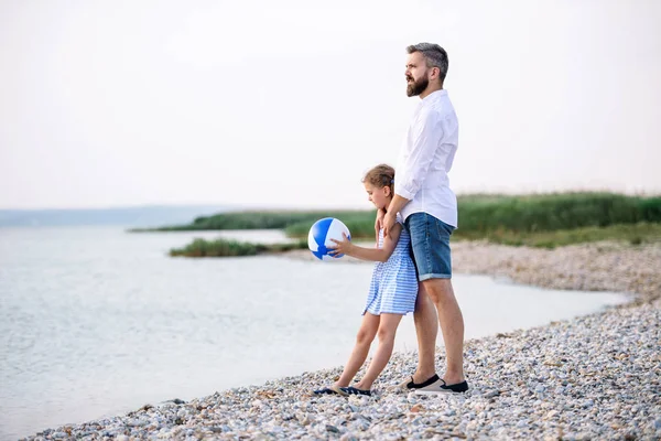 Olgun baba ve göl kenarında oynarken bir tatil de küçük kızı. — Stok fotoğraf