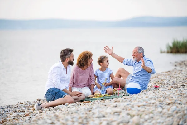 Rodina multigenerace na dovolenou u jezera, piknik. — Stock fotografie