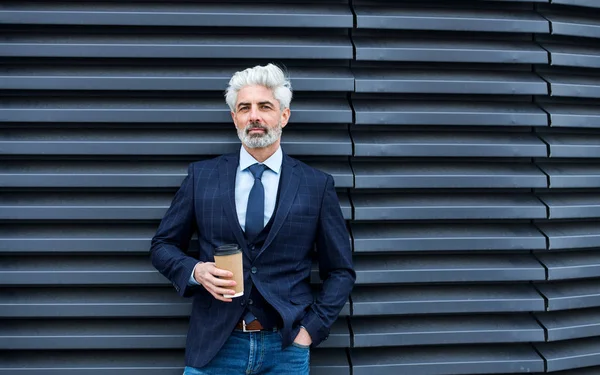 Un homme d'affaires mature debout à l'extérieur, tenant un café. Espace de copie . — Photo