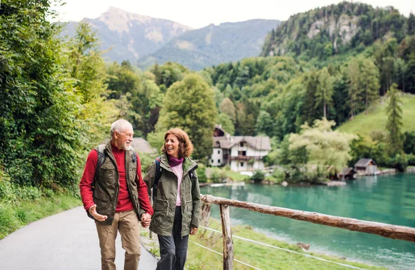 Una pareja de jubilados senderismo en la naturaleza, tomados de la mano . — Foto de Stock