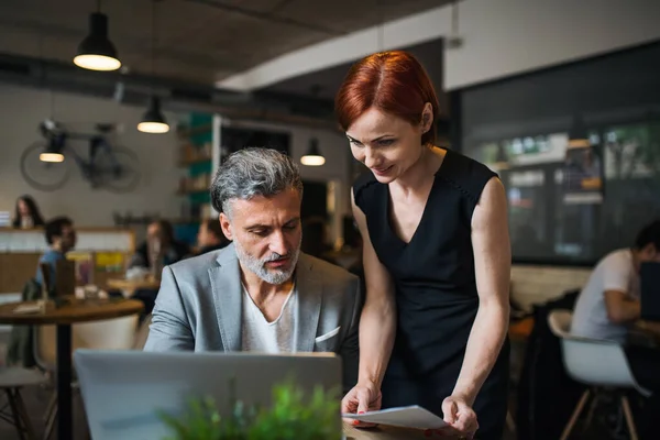 Homem e mulher tendo reunião de negócios em um café, usando laptop . — Fotografia de Stock