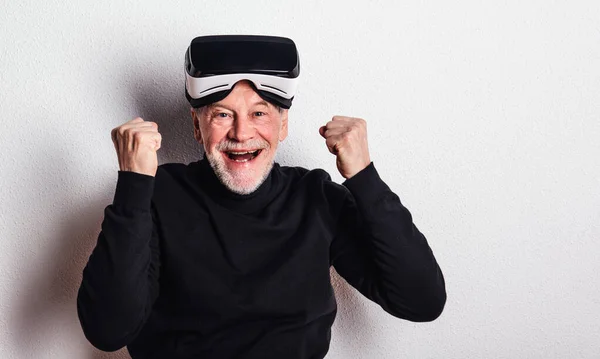 Porträtt av en glad senior man med Vr goggles i en studio. — Stockfoto
