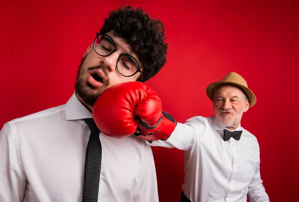 Estudio de joven versus vieja generación, padre e hijo con guante de boxeo . —  Fotos de Stock