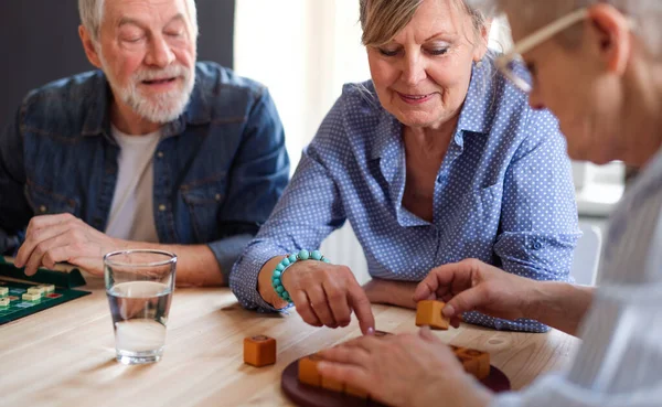 Grupo de personas mayores jugando juegos de mesa en el club del centro comunitario . — Foto de Stock