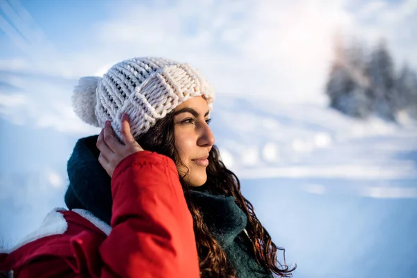 雪の冬の森の中で屋外に立っている若い女性の正面図. — ストック写真