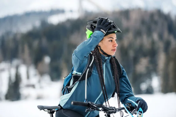 Vrouwelijke mountainbiker buiten in de winter natuur. — Stockfoto