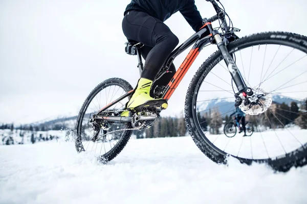 Střední část horského bikeru jezdila v zimě venku na sněhu. — Stock fotografie