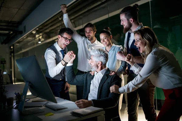 Un grupo de empresarios con ordenador en una oficina, expresando emoción . — Foto de Stock