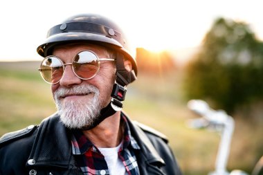 Kırsalda motosikletle gezen neşeli, kıdemli bir gezgin..