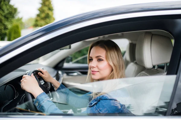 Ung kvinna förare sitter i bilen, väntar. — Stockfoto