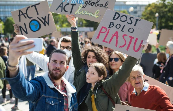 Люди с плакатами и плакатами о глобальной забастовке за изменение климата, делают селфи . — стоковое фото