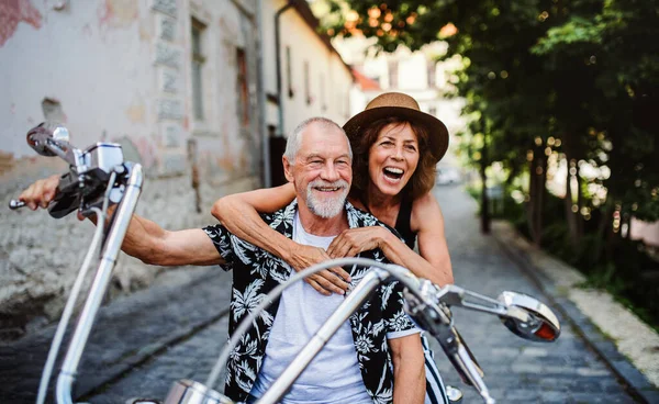 Kasabada motosikletli neşeli yaşlı çift gezginleri. — Stok fotoğraf
