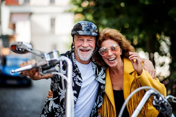 Een vrolijk stel senioren met motor in de stad. — Stockfoto