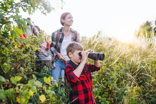 Groep schoolkinderen met leraar op excursie in de natuur, met een verrekijker. — Stockfoto