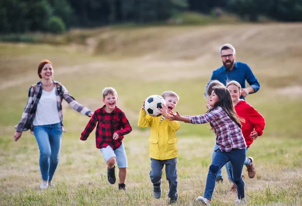 Group of school children with teacher on field trip in nature, playing with a ball. — Stock Photo, Image