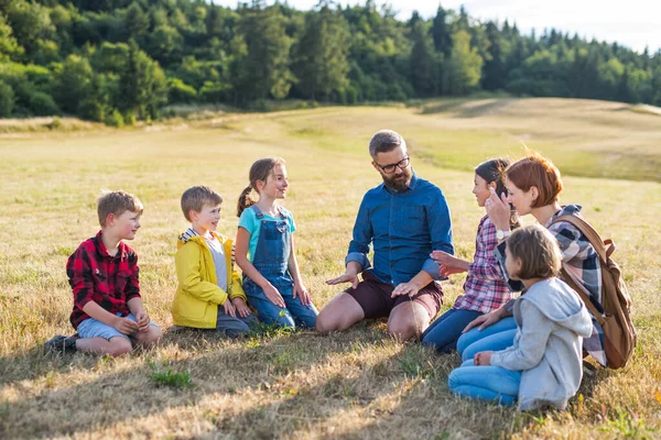 Grupa uczniów z nauczycielem na wycieczce w przyrodzie, rozmowy. — Zdjęcie stockowe